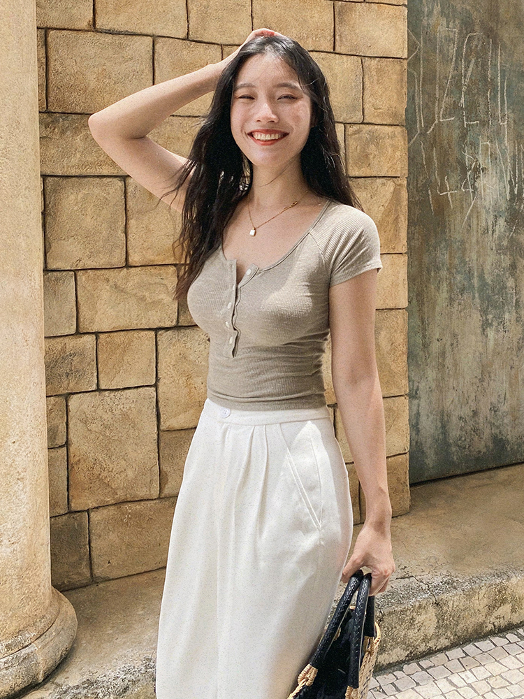 Slim-Fit White Knitted T-Shirt for Women, Short Sleeve with Button Detail, French Style, Chest-Highlighting Design Slim-Fit White Knitted T-Shirt for Women, Short Sleeve with Button Detail, French Style, Chest-Highlighting Design